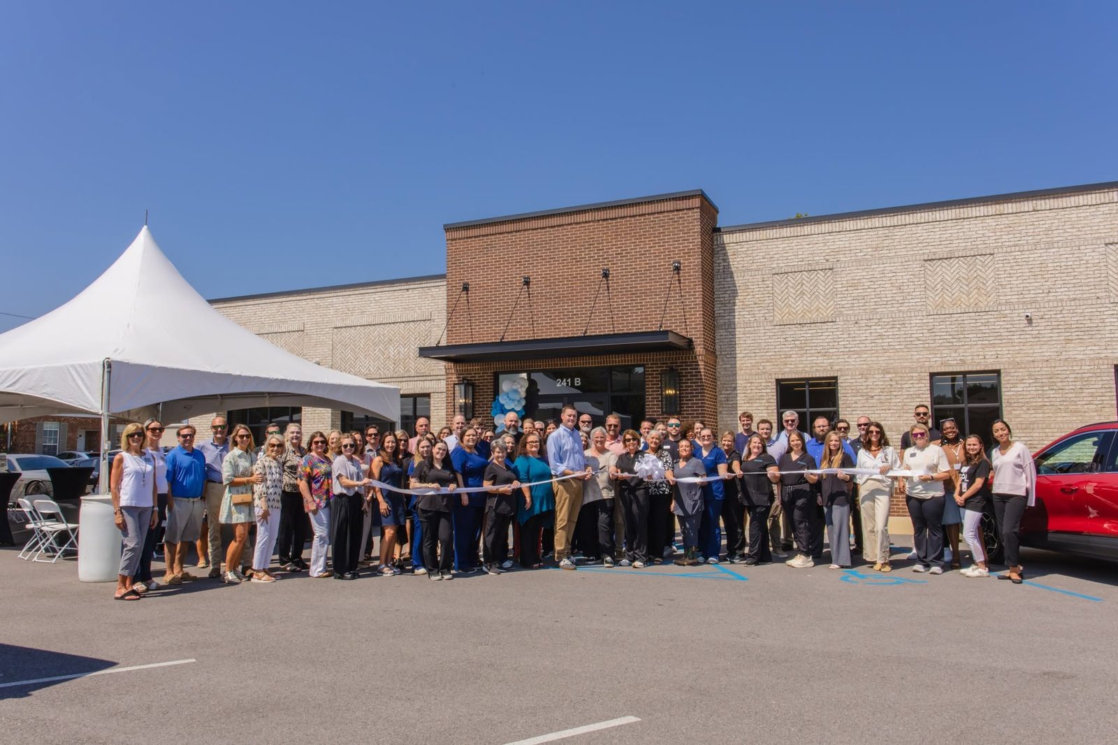 Wide view of the ribbon cutting ceremony with the Etowah Chamber of Commerce outside the Gadsden office
